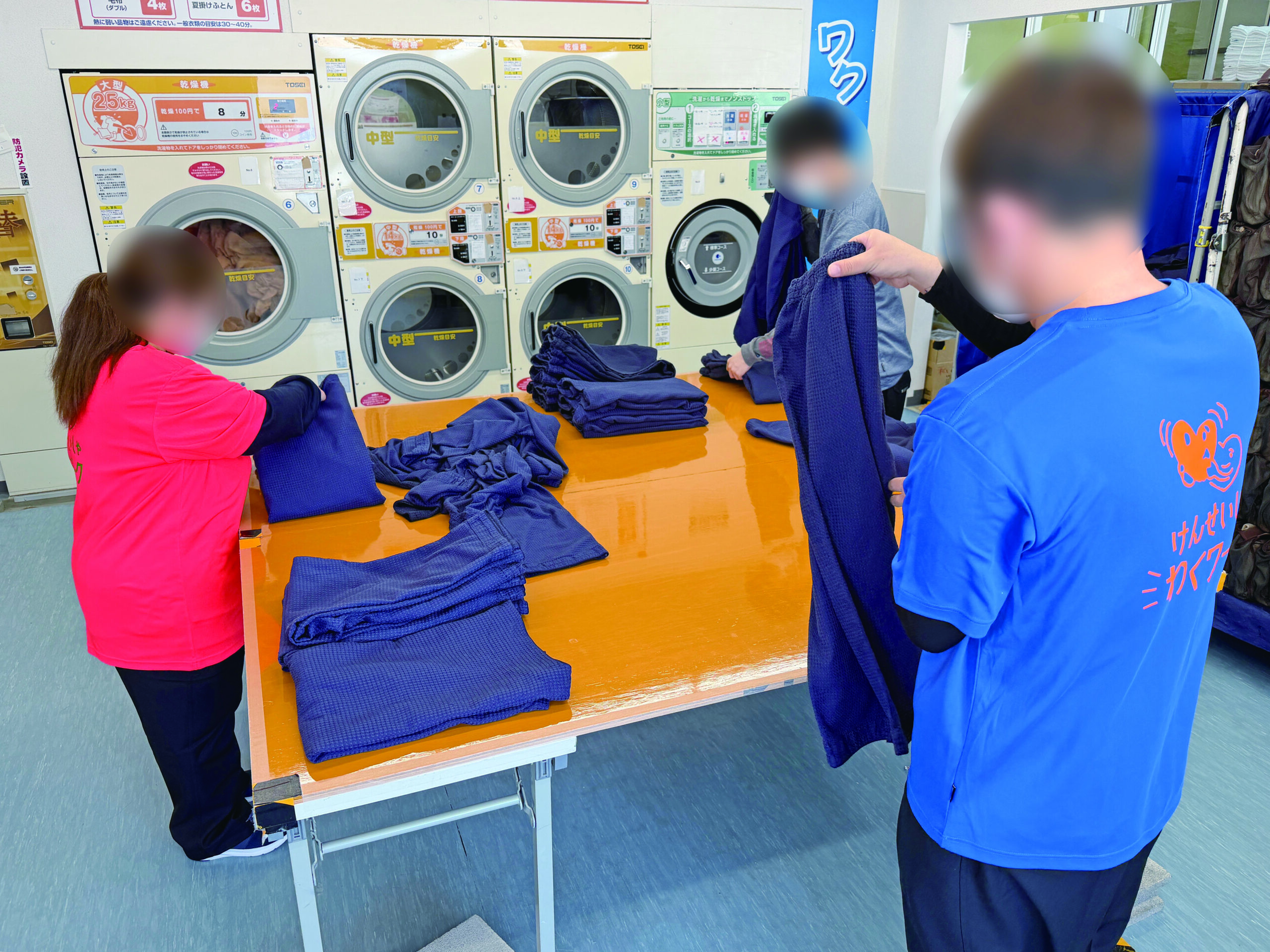 従業員が洗濯物を畳んでいる様子